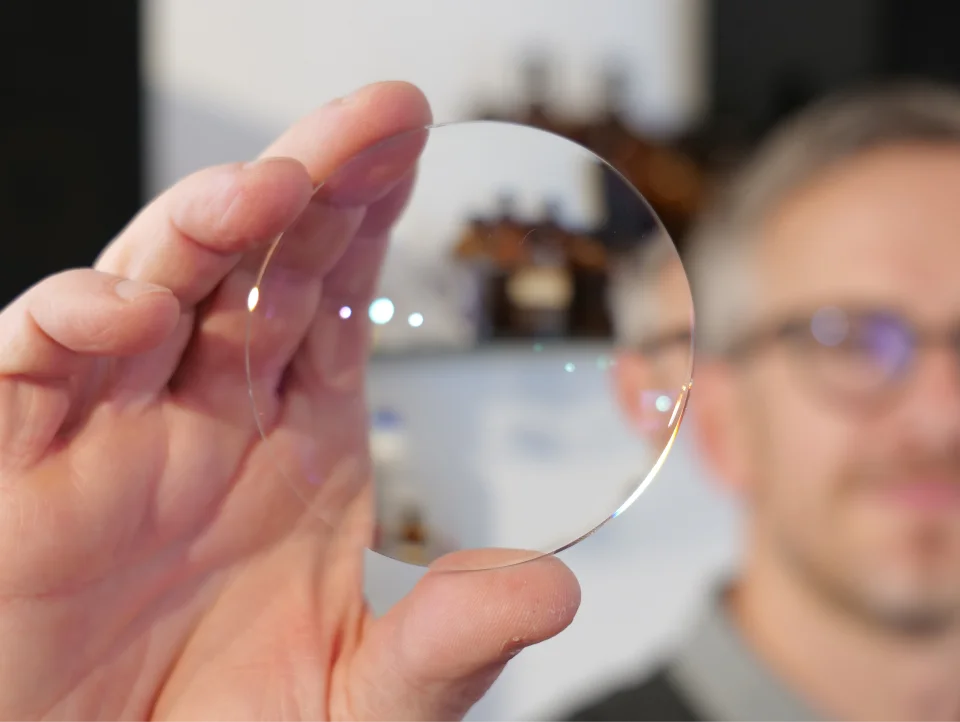 ptiker hält ein Brillenglas – professionelle Brillenglasberatung in Dietzenbach